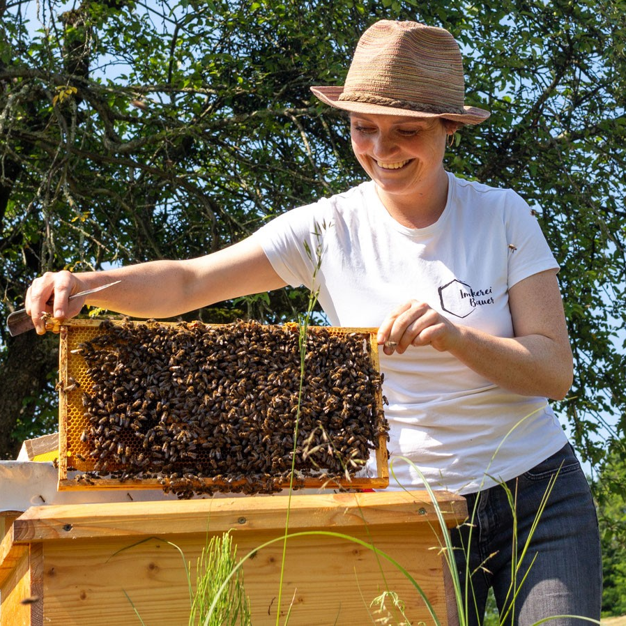 Imkerin mit Bienen im Garten